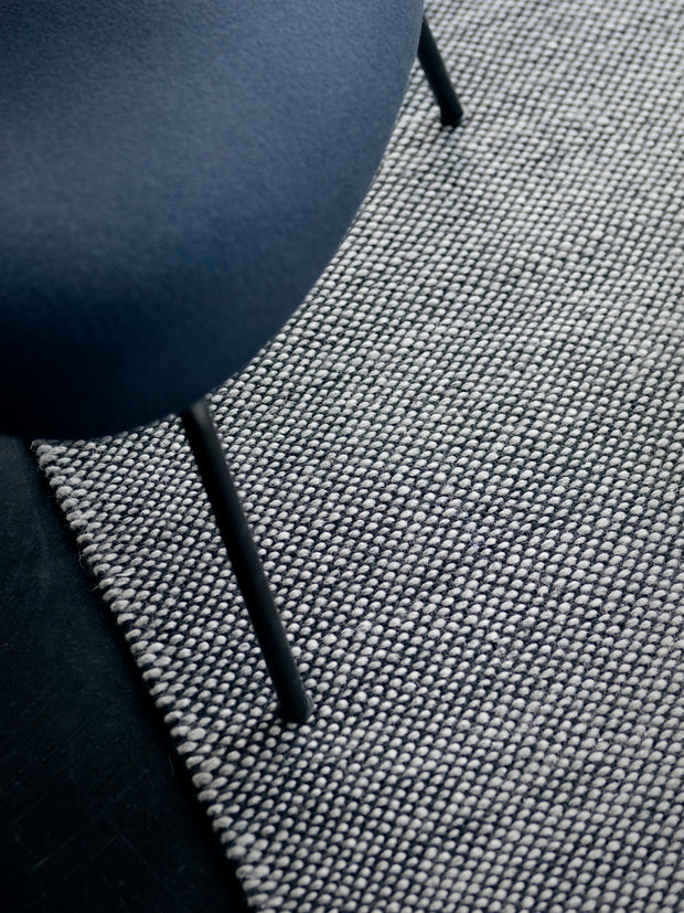 Close-up of a textured gray surface with a dark blue object partially visible.